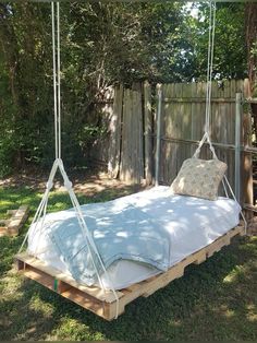 a swing bed made out of pallets in the yard