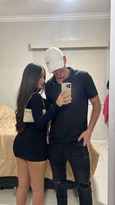 a man and woman taking a selfie in the mirror