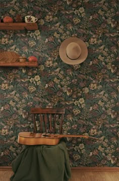 a wooden chair sitting in front of a wall with a hat on top of it