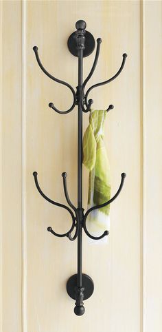 a coat rack with two coats hanging from it's sides and a towel on the other side