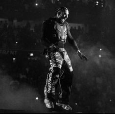 a man standing on top of a skateboard in front of a crowd