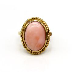 -  Presented is a lovely 18 karat yellow gold and coral ring. This is a relatively  contemporary piece, but the style is reminiscent of antique coral rings, very  elegant. The ring is set with a beautiful oval cabochon of peachy pink coral  inside a ropetwist border. The coral cabochon measures about 15.7 by 11.3  millimeters.  This ring is stamped and guaranteed 18k (750=18k), as well as a maker's mark  of AJF.  This ring is in excellent condition. The coral is well set with no chips.  The ring Elegant Oval Coral Rings, Elegant Coral Oval Rings, Oval Coral Cabochon Jewelry, Coral Oval Cabochon Jewelry, Elegant Oval Coral Jewelry, Elegant Coral Oval Jewelry, Coral Oval Jewelry For Weddings, Coral Rings, Mixed Metal Bracelets