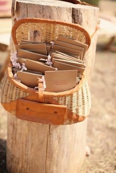 a basket filled with lots of books sitting on top of a wooden pole