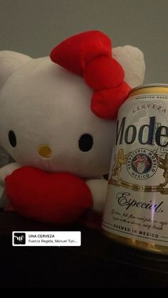 a hello kitty stuffed animal next to a can of beer