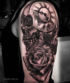 a black and white photo of a skull with a rose on it's arm