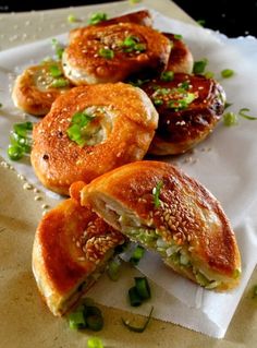 some food is laying out on a white paper towel with green onions and sesame seed sprinkles