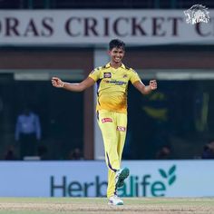 a man in yellow uniform running on a field with his arms out and legs spread wide