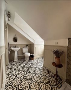 an attic bathroom with black and white tile flooring