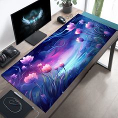 a computer desk with a painting on it