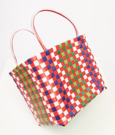 This charming 1970s style accessory features a vibrant color combo of red, green, blue, and white that screams retro chic. The durable plastic material ensures this bag will be your go-to for all your sunny day outings. With convenient plastic handles, you can easily carry all your essentials in style.Available while supplies last. 1970s Style, 1970s Fashion, Woven Basket, Basket Bag, Retro Chic, Color Combo, Sunny Day, Plastic Material, Color Combos