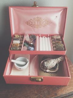 an open pink box with candles and other items in it