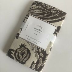 a small notebook with a black and white pattern on the cover, sitting on top of a table