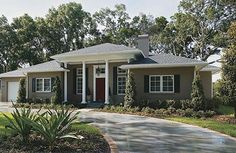 a house with green shutters and trees in the front yard on a sunny day