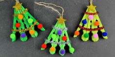 three christmas tree ornaments made out of popsicle sticks with pom - poms