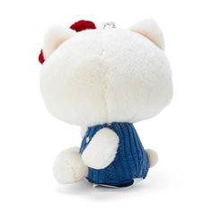 a white stuffed animal with a blue sweater on it's chest and red hair