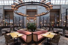 the interior of a restaurant with tables, chairs and chandeliers hanging from the ceiling