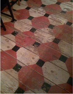 the floor is covered with red, white and black tiles in an old - fashioned room