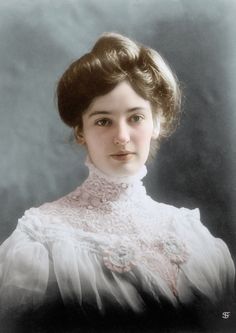 an old photo of a woman in a white dress with her hair pulled back and wearing a lace collar