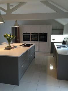 a large kitchen with an island in the middle and two ovens on each side