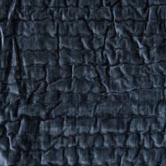 an up close shot of the texture of a dark blue velvet fabric with wavy lines