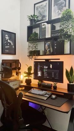 a desk with a computer and plants on it