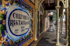 the entrance to an outdoor restaurant with colorful tiles on it's walls and pillars