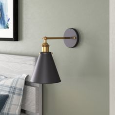 a lamp is on the wall next to a bed