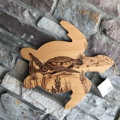 a wooden cutout of a turtle swimming in the water