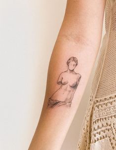 a woman's arm with a small tattoo on the left side of her arm