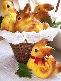 some bread buns in a basket with little yellow chickens sitting on top of them