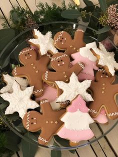 a glass bowl filled with lots of decorated cookies