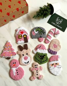 twelve handmade christmas mitts and decorations on a table