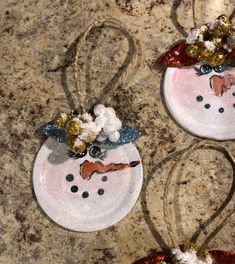 two snowman ornaments are sitting on the ground