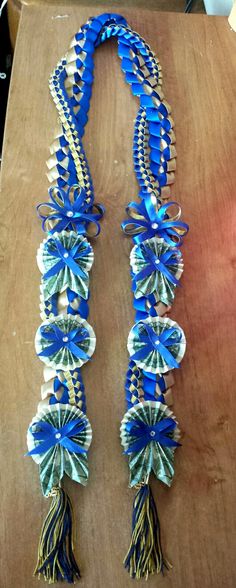 a blue and white necklace with tassels on it sitting on a wooden table