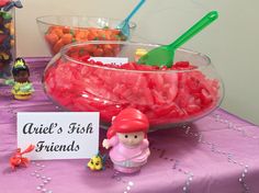 there is a bowl full of candy and a sign that says ariel's fish friends