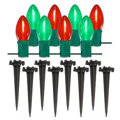 red and green christmas lights are lined up against a white background with black spikes on each end