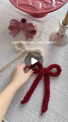 someone is making a bow out of crochet yarn and yarn balls on the table