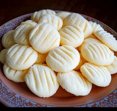 a plate filled with white cookies on top of a table