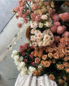 a basket filled with lots of flowers on top of a floor next to a bag