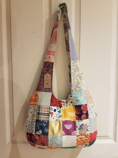 a multicolored patchwork purse hanging on a door