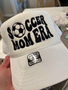 Soccer mom era hat Trucker hat style, white hat, with black stitching White Snapback Visor Hat With Letter Print, White Letter Print Snapback Visor Hat, White Letter Print Visor Snapback Hat, White Casual Snapback Hat With Letter Print, White Baseball Cap For Sports Events, Casual White Baseball Cap With Letter Print, Casual White Pre-shrunk Snapback Hat, White Baseball Cap For Baseball Season, White Sports Hat For Baseball Season