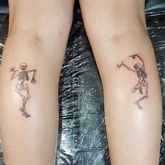 two tattoos on the legs of people who are both wearing skeleton suits and holding hands