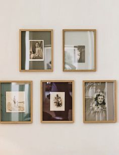 four framed photographs hang on the wall above a bed