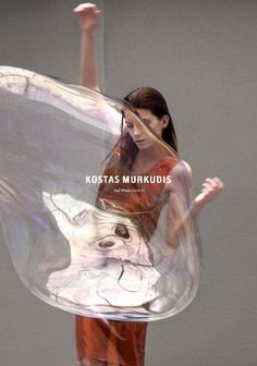 a woman is holding a large plastic object in her hand and the words kostas murkudiis on it