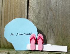 a pair of pink flip flops sitting on top of a wooden floor next to a sign that says mr john smith