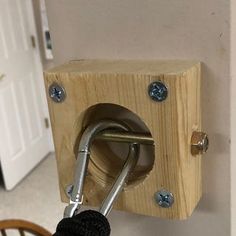 a close up of a hook on a wall with a wooden block attached to it