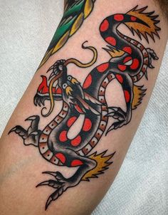 a black and red dragon tattoo on the arm