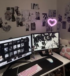 two computer monitors sitting on top of a desk next to a teddy bear and pink keyboard