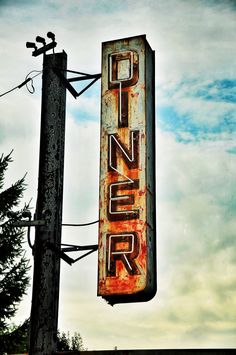 an old sign that is on the side of a pole