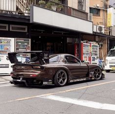 a brown sports car is parked on the street